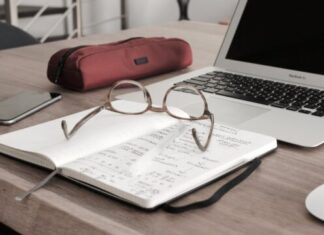 A Guide to CPA Tax Preparation eyeglasses on book beside laptop