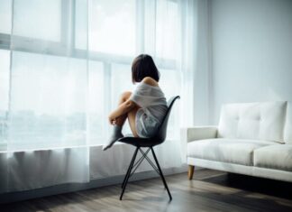 How Depression Takes Control of Your Life: Signs, Diagnosis, and Treatment Plans woman sitting on black chair in front of glass-panel window with white curtains