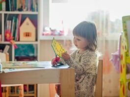 Children and Art Girl In White Long Sleeve Dress Sitting On Brown Wooden Chair Cutting Paper