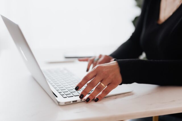 Photo by Karolina Grabowska Crop unrecognizable female entrepreneur in casual clothes using touchpad on laptop while working at table in contemporary office