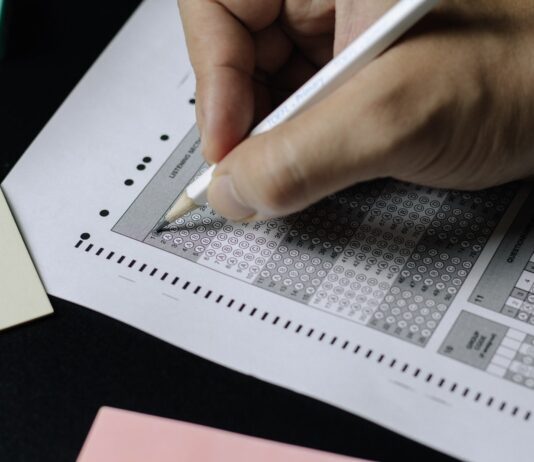 Enabling Secure Remote Proctored Exams through Online Assessment Solutions person writing on white paper