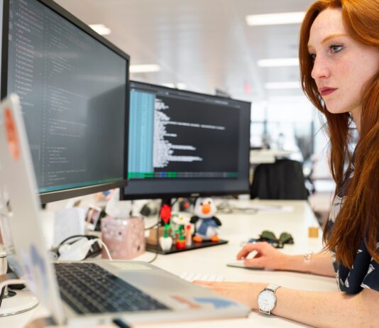 Where SaaS Startups Can Hire Software Developers woman in green shirt sitting in front of computer