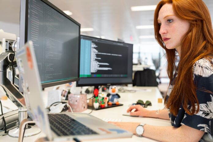 Photo by ThisisEngineering RAEng woman in green shirt sitting in front of computer