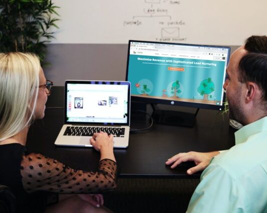 Using HubSpot for Effective Inbound Marketing Strategies man and woman sitting down in front of table