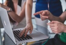 Strategies for Promoting Your Consulting Business person touching and pointing MacBook Pro