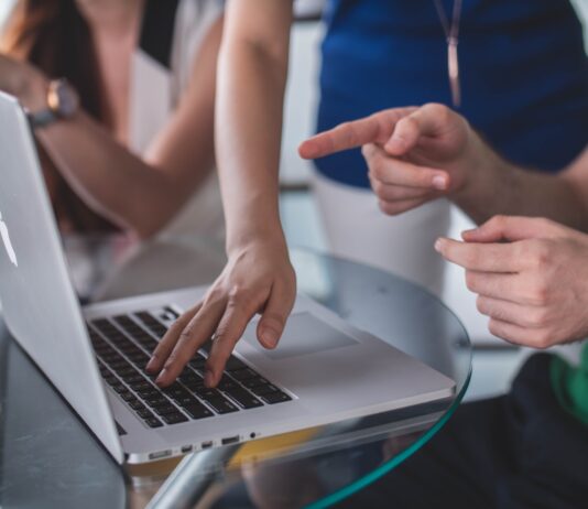 Strategies for Promoting Your Consulting Business person touching and pointing MacBook Pro