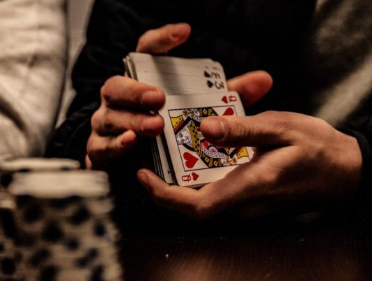 The Case for Playing Low-Stakes Poker person holding king of spade playing card