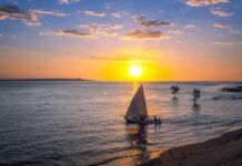 Bitcoin Trading System Impacts on the Businesses of Madagascar silhouette of people riding on sail boat on sea during sunset