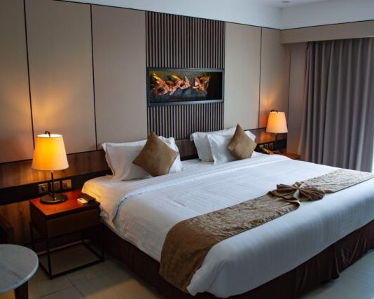 How to Make Your Hotel More Sustainable on a Budget white bed linen with throw pillows