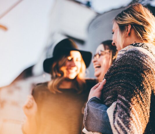 9 Key Ways You Can Work On Improving Your Mental Health This Year people laughing and talking outside during daytime