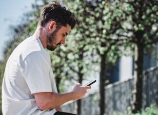 Enhancing the Game: The Impact of Technology in Transforming Online Casino Experiences man in white dress shirt and black shorts sitting on brown concrete bench during daytime