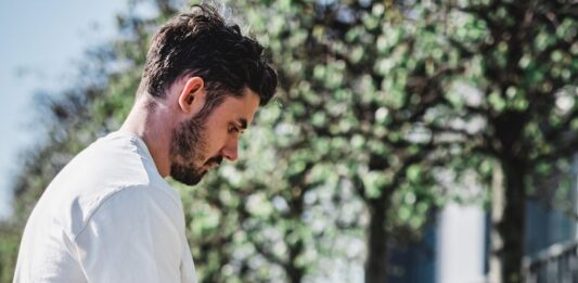 Enhancing the Game: The Impact of Technology in Transforming Online Casino Experiences man in white dress shirt and black shorts sitting on brown concrete bench during daytime