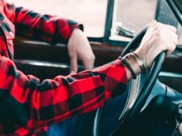 Driving Efficiency: Benefits of Car Rental Management Software person holding steering wheel