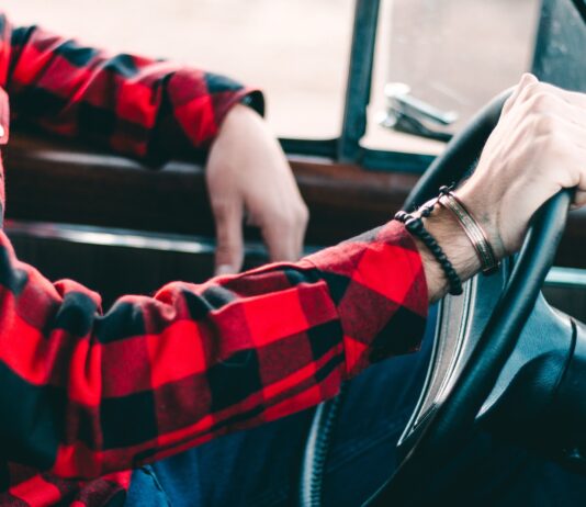 Driving Efficiency: Benefits of Car Rental Management Software person holding steering wheel