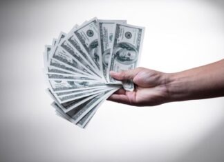 The Dollar Finding its Feet Again – What Should Investors Expect? person holding 100 US Dollar banknote