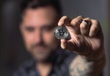 Cryptocurrency and Online Casino Person Holding Silver Bitcoin Coin