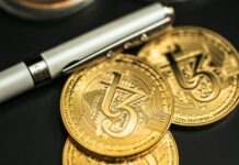 USDT and USDС: Latest Updates a pen sitting on top of a pile of gold coins