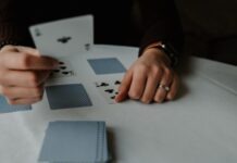 The Most Popular Online Card Games In 2023 person holding playing cards on white table
