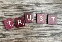 Common Misconceptions About Trusts and How to Address Them trust spelled with wooden letter blocks on a table