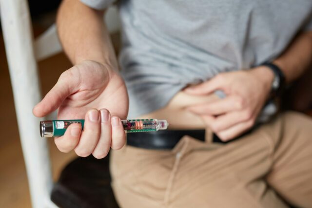 Photo by Sweet Life a man sitting down holding an electronic device