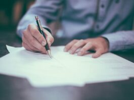 Championing Your Cause: Why You Need a Personal Injury Lawyer to Claim Compensation man writing on paper
