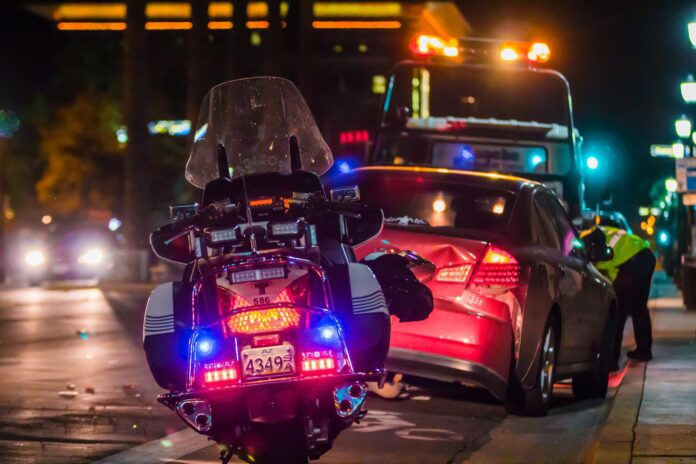 a motorcycle and a car on a street at night