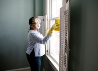 The Challenges of DIY Conservatory Cleaning and How to Overcome Them woman in white long sleeve shirt and blue denim jeans standing beside white wooden framed glass