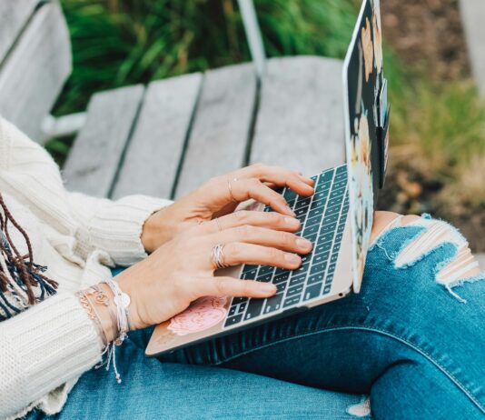 CooMeet – Omegle TV Alternative for Meeting New People person in white long sleeve shirt and blue denim jeans using macbook pro