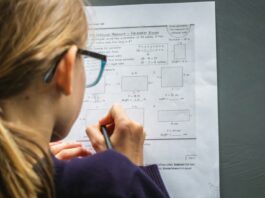 Tailoring Tests for Diverse Learning Needs in High Schools woman in black framed eyeglasses holding pen