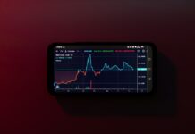 How is Cryptocurrency Transforming the Gaming Industry? a cell phone displaying a stock chart on a red background