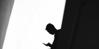 Discovering Hidden Gems: Lesser-Known Features of 918kiss, Mega888, and Pussy888 person using phone leaning on wall in silhouette photography