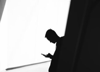 Discovering Hidden Gems: Lesser-Known Features of 918kiss, Mega888, and Pussy888 person using phone leaning on wall in silhouette photography