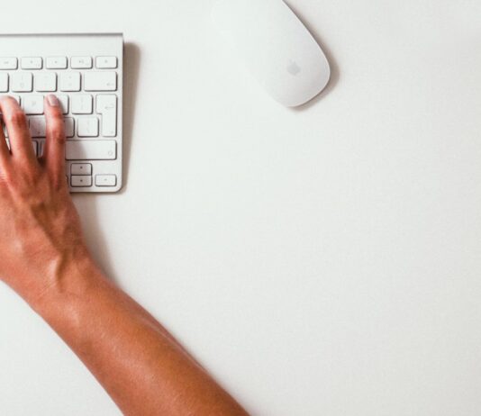 Best AI Tools for Job Seekers: Optimize Your Search person typing on Apple Cordless Keyboard