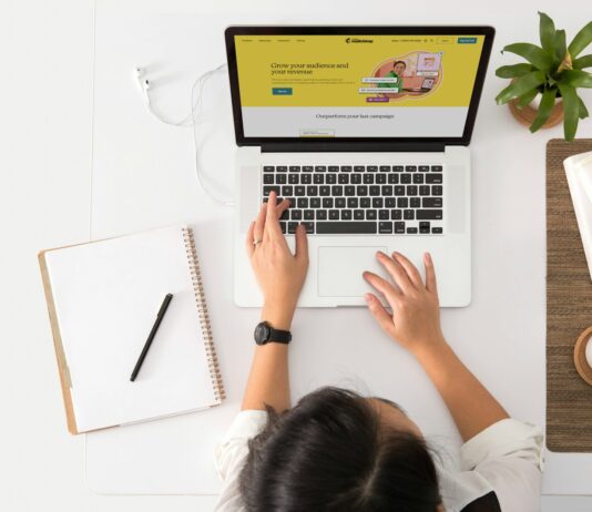 Is Your Brand Voice Helping or Hurting Your Reputation? a person sitting at a desk with a laptop and a coffee cup