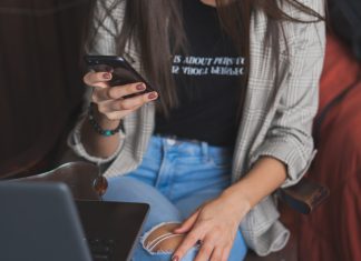 Tips and Strategies for Successful Aviator Gaming woman in white cardigan holding black smartphone