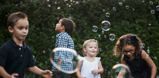 The Role of Play in Developing Essential Skills girl in white dress standing beside man in blue and white plaid dress shirt