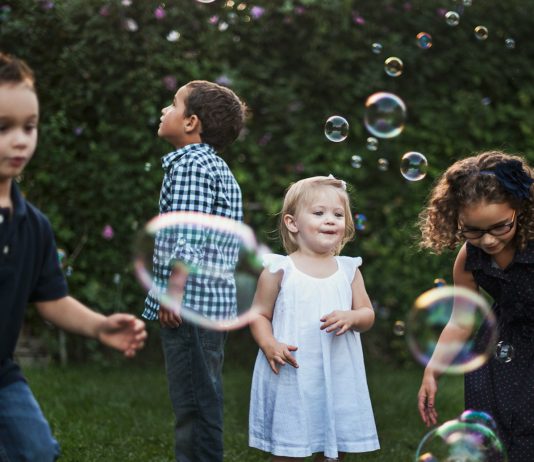The Role of Play in Developing Essential Skills girl in white dress standing beside man in blue and white plaid dress shirt