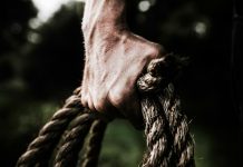 Can Surgery Fix a Weak Grip? The Answer Might Surprise You A close-up image shows a strong, firm hand gripping a thick, rough rope, showcasing strength and determination in an outdoor setting.