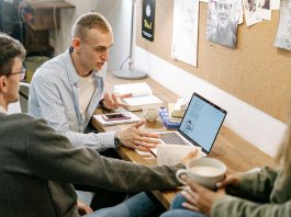 The Future of Online Master’s Education: Trends and Technologies Shaping the Way We Learn Young adults collaborating over laptops and notes during a study session indoors.