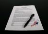 Short-Term Rental Licensing Reforms Across Jurisdictions Lease agreement document with pen and American flag keychain on a black table.