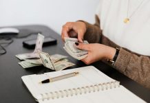Common Budgeting Mistakes and How to Avoid Them Close-up of person counting cash with notepad on desk, indicating financial tasks.