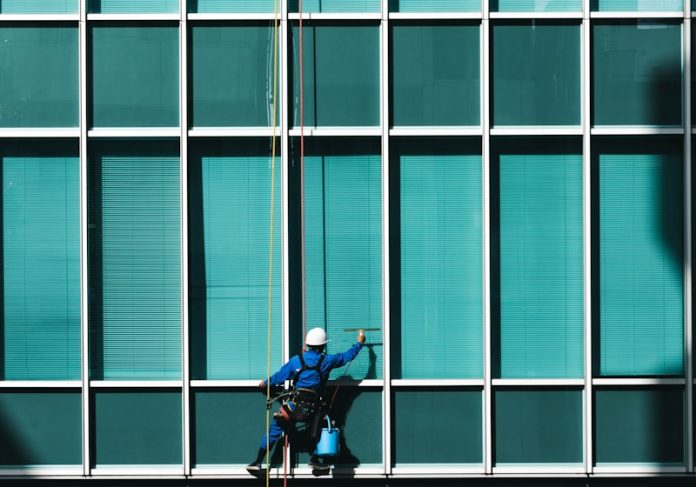 Photo by Ryoji Iwata man cleaning glass mirrors