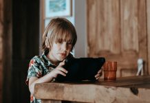 How to Get Your Kids Off Screens Without a Meltdown selective focus of child using tablet computer on table
