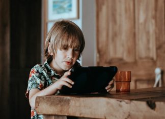 How to Get Your Kids Off Screens Without a Meltdown selective focus of child using tablet computer on table