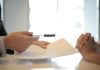 Why We Should Take The Time To Evaluate And Review Our Life Insurance Policy Close-up of a contract signing with hands over documents. Professional business interaction.