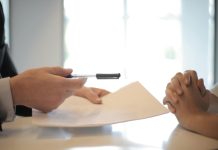 Why We Should Take The Time To Evaluate And Review Our Life Insurance Policy Close-up of a contract signing with hands over documents. Professional business interaction.