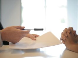 Why We Should Take The Time To Evaluate And Review Our Life Insurance Policy Close-up of a contract signing with hands over documents. Professional business interaction.