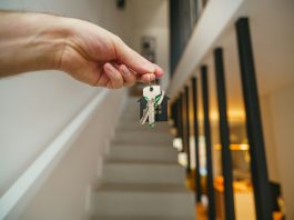 Exploring What Landlords Need to Know About Insurance Obligations Here's a possible caption: keys being held in front of a staircase.