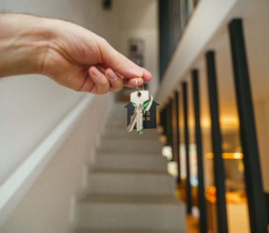 Exploring What Landlords Need to Know About Insurance Obligations Here's a possible caption: keys being held in front of a staircase.