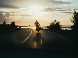 Maximizing Compensation After a Motorcycle Accident: New York Legal Strategies Silhouette of a motorcyclist riding on a scenic road during a beautiful sunset, emphasizing freedom and adventure.